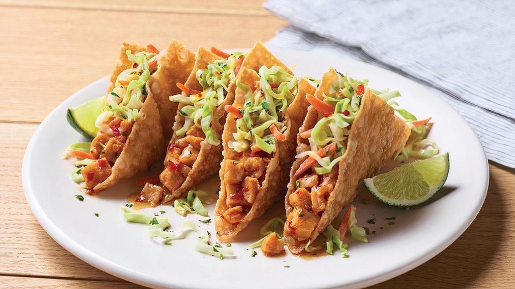 Grilled Chicken Wonton Tacos · Sweet Asian chile marinated grilled chicken stuffed into crispy wonton shells topped with our signature coleslaw and cilantro.