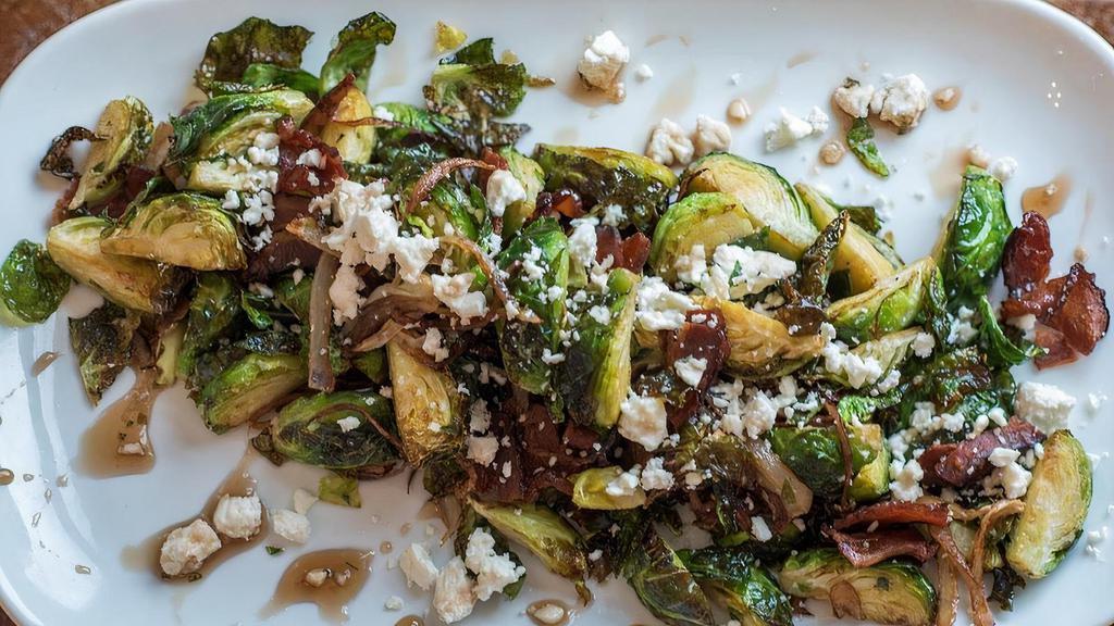 Brussels Sprouts · Warm & crispy sprouts, shallots & bacon tossed in a sweet & tangy balsamic dressing. Topped with creamy chevre.