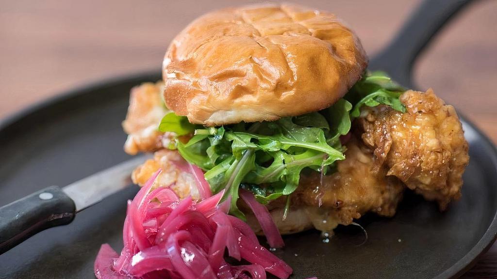 Fried Chicken Sammy · Two chicken cutlets tossed in apricot bourbon hot honey with Swiss, pickled onion, arugula and lemon basil aioli on brioche roll