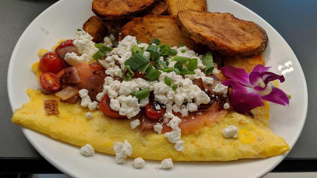 Smoked Salmon & Goat Cheese Omelette · Fresh smoked salmon, goat cheese, red onion, tomato, scallions inside.  Comes with breakfast potatoes and toast or English muffin upon request.