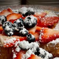 French Toast With Berries · 2 home made French toast with powder sugar on top and chocolate syrup on the side.