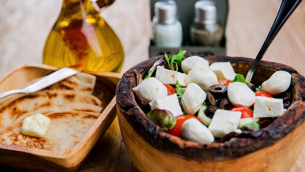 Mixed Green Salad · Served with toasted pita bread. Mixed greens with cucumbers, tomatoes, olives, and fresh mozzarella or feta cheese. Drizzled with oil and vinegar.