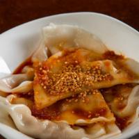 Dumplings In Chili Oil · Spice level 4/10. Eight steamed pork dumplings in sweet chili sauce, topped with sesame seed...
