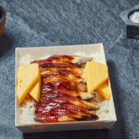 Unagi Don · Grilled freshwater eel on a bed of white rice garnished with sesame seed, tamago, and daikon.