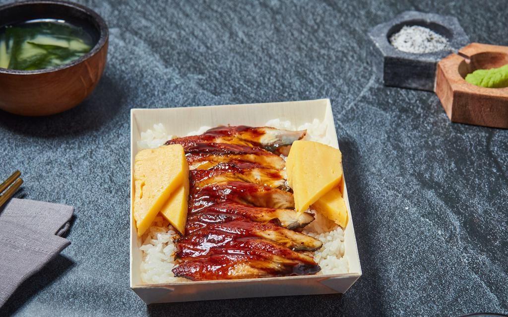 Unagi Don · Grilled freshwater eel on a bed of white rice garnished with sesame seed, tamago, and daikon.