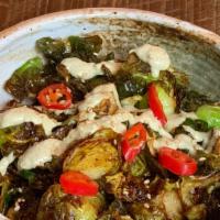 Brussel Sprouts · Crispy brussels tossed in a sweet soy glaze and drizzled with charred scallion sour cream.