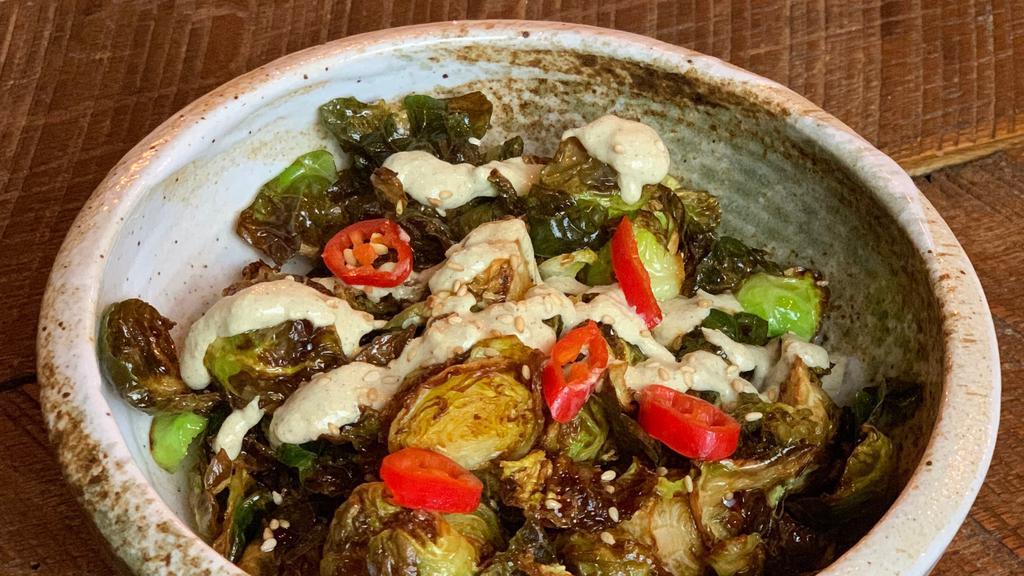Brussel Sprouts · Crispy brussels tossed in a sweet soy glaze and drizzled with charred scallion sour cream.