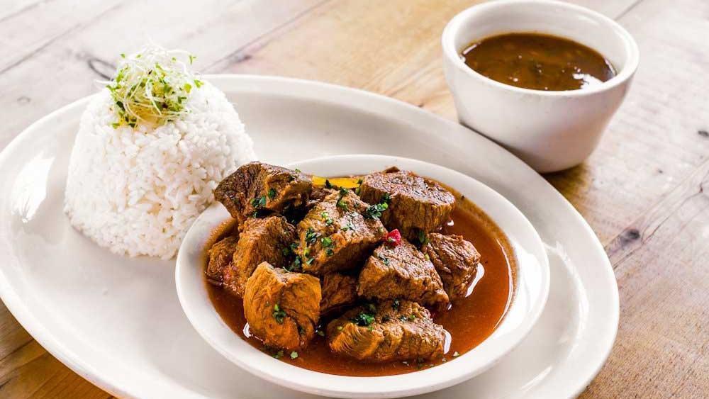 Carne Guisada · Beef stew served with white rice and red beans.