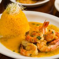 Camarones Al Ajillo · Garlic shrimp simmered in a white wine sauce served with yellow rice and black beans.
