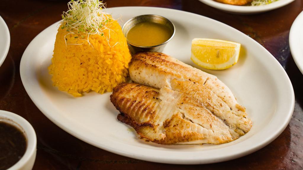 Tilapia · Pan-roasted tilapia served with yellow rice and black beans.