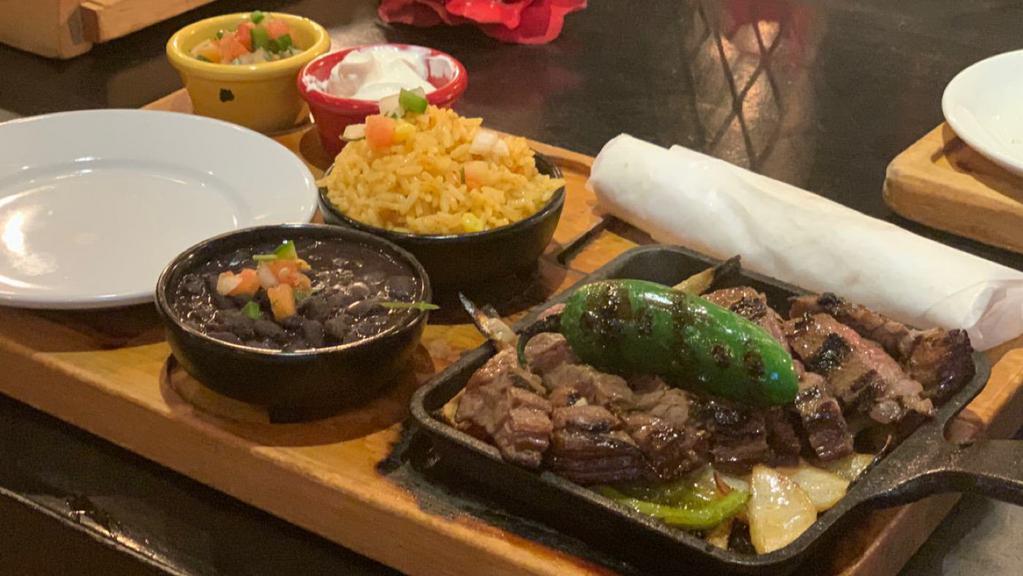 Steak Fajitas · Served with mexican rice black beans pico de gallo sour cream and flour tortillas. choice of guacamole or cheese.
