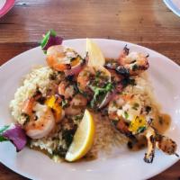 Jumbo Shrimp Kebobs · Jumbo shrimp skewered with peppers and onions, over rice pilaf and topped with a lemon garli...