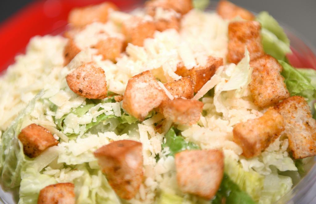 Caesar Salad · Crisp romaine hearts and aged parmesan topped with homemade croutons and tossed with homemade Caesar dressing.
