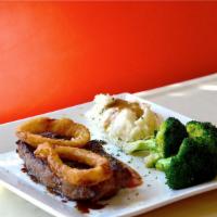 New York Strip Steak · Topped with onion rings, served with potatoes, vegetables, and soup.