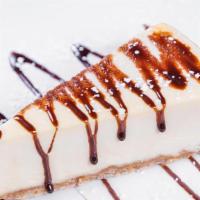 Cheesecake · Drizzled with chocolate & powdered sugar.