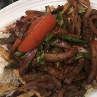 Lomo Saltado · Tender beef sautéed with onions and tomatoes in a soy sauce served with French fries and whi...