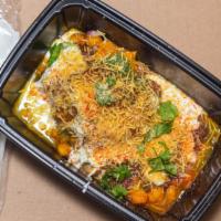 #29. Samosa Chaat · Crispy potatoes, green peas filled & topped with home-made spices, yogurt & chutney.