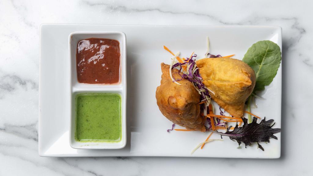 Samosas · Indian fried pastry with a savory filling of spiced potatoes, onions, peas and lentils (2 pcs).