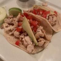 Tacos Al Pastor · Pork marinated in guajillo sauce, grilled pineapple, onion, cilantro, and green tomatillo sa...