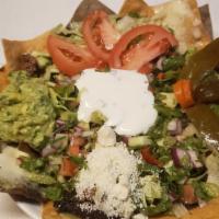 Chicken Nachos · Corn tortilla Chips with beans, melted cheese, sour cream, lettuce, tomatoes, jalapeños and ...