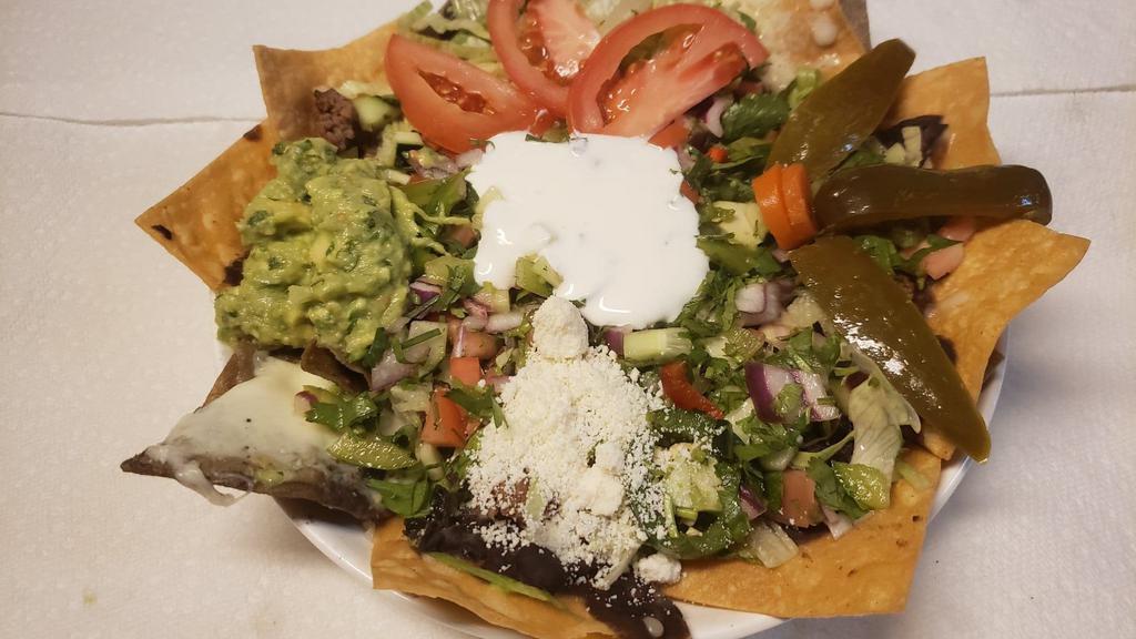 Fried Pork Nachos · Corn tortilla Chips, beans, melted cheese, sour cream lettuce, tomatoes, jalapeños and guacamole