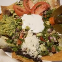 Steak Nachos · Corn tortilla Chips, beans, melted cheese, sour cream, lettuce, tomatoes, jalapeños and guac...