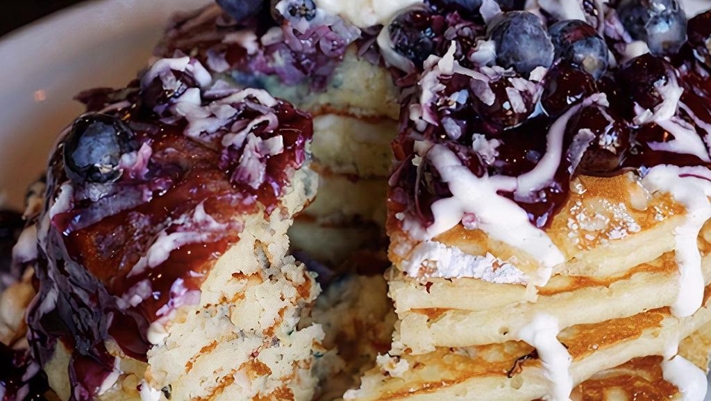 Berry Sour Bliss Pancakes · Buttermilks baked with blueberries and coconut, topped with our warm blueberry compote and drizzled with fresh sour cream.