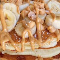 Honky Tonk Pancakes · Buttermilks baked with peanut butter chips and topped with slices of fresh bananas, and driz...