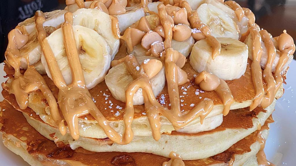 Honky Tonk Pancakes · Buttermilks baked with peanut butter chips and topped with slices of fresh bananas, and drizzled with peanut butter sauce.