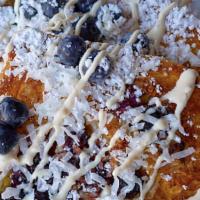 Blueberry Coconut Bliss French Toast · Our fresh baked challah bread stuffed with fresh blueberries and shredded coconut, topped wi...