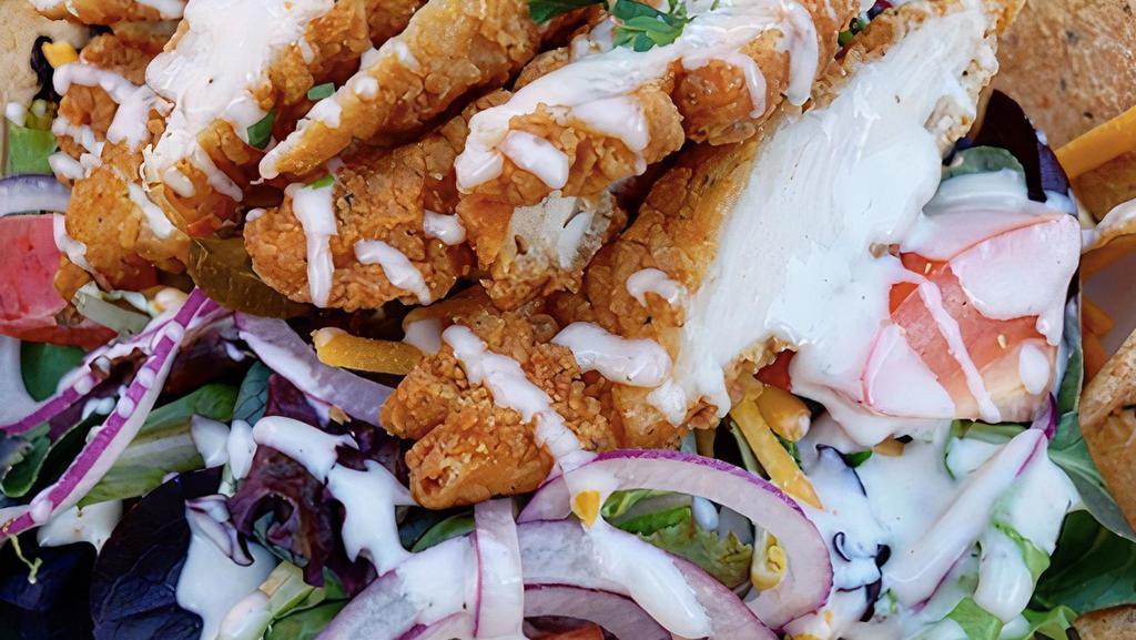 Southwest Chicken Salad · Crispy fried chicken tender strips, jalapenos, cucumbers, tomato, red onions, sweet corn, avocado and sharp cheddar cheese atop mixed greens and crispy fresh baked tortillas with our creamy buttermilk ranch dressing. All our salads are made with fresh locally sourced ingredients.