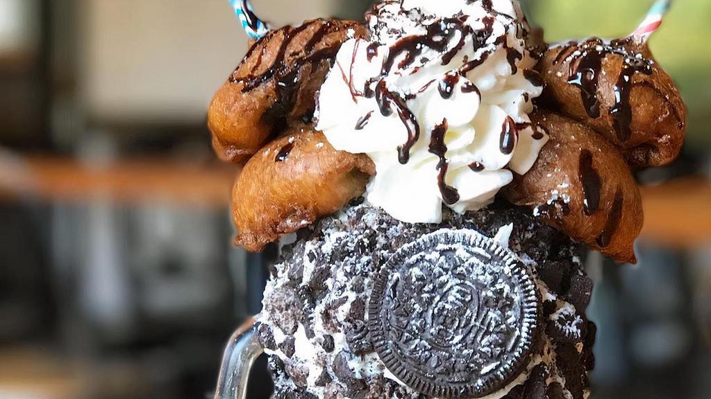Fried Oreo Cookie Shake · Our oreo cookie shake in an oreo crumb decorated glass, topped with whipped cream, fried oreos, and chocolate sauce.