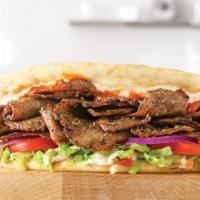 Spicy Greek Gyro · Greek gyro meat served on a warm flatbread topped with tzatziki sauce and a spicy chili sauc...