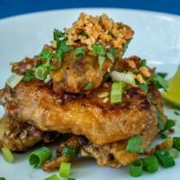 Viet-Style Chicken Wings · Home battered wings, garlic, fermented caramel sauce, chili, peppers.
