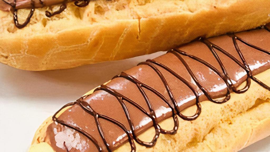 Classic Éclair · Puff pastry filled with vanilla bean custard, topped with chocolate icing and milk chocolate drizzle
