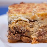 Moussakas · Traditional Greek casserole with béchamel sauce, ground beef, eggplant, and potatoes.