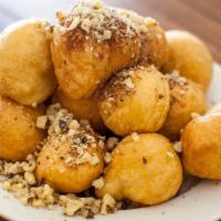 Loukoumades · Fried dough drizzled with honey, walnuts and cinnamon.