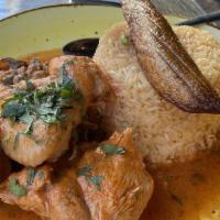 Seco De Gallina · Delicious slow-cooked hen served with sweet yellow plantain and yellow rice.