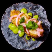 Fish Taco · Baja-style fried fish taco with avocado salsa and pickled onions.