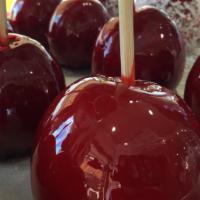 Red Candy Apple With White Coconut · Granny smith apple covered in our storemade red candy and rolled in coconut.