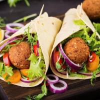 The Falafel Wrap · Fresh made falafels wrapped in warm pita bread topped with lettuce, tomatoes and chef's sauce.