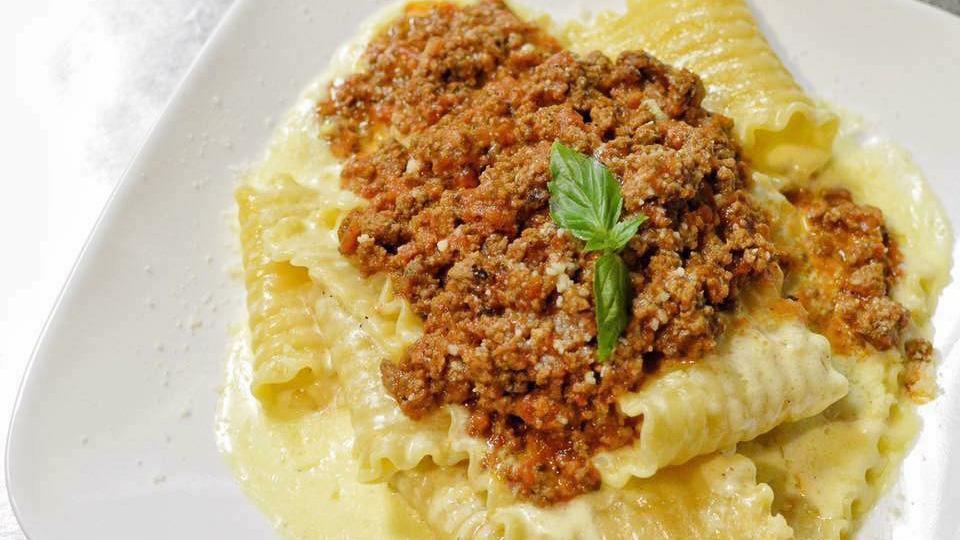 Pappardelle · lasagna style pasta sheets in a rich alfredo sauce with a dollop of pork & beef meat sauce on top.