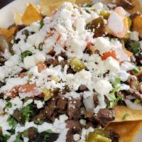 Nachos Con Carne · Tortilla chips with beans chap cheese sour cream and pico de gallo. Choice of meat: Chicken,...