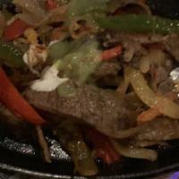 Bistec A La Tampiquena · Steak sauteed with onions and peppers and served with cheese enchilada
