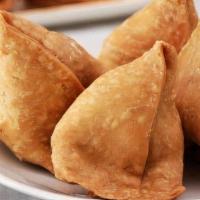 Vegetable Samosa · Crisp turnover filled with mildly spiced potatoes and peas. Served with mint and onion chutn...