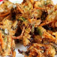 Vegetable Pakora · Fresh vegetable dipped in a special batter and fried to golden perfection. Served with mint ...