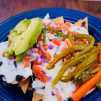Homemade Nachos · We homemake our own chips, topped it with homemade bleak beans, Oaxaca cheese, crema, onion,...