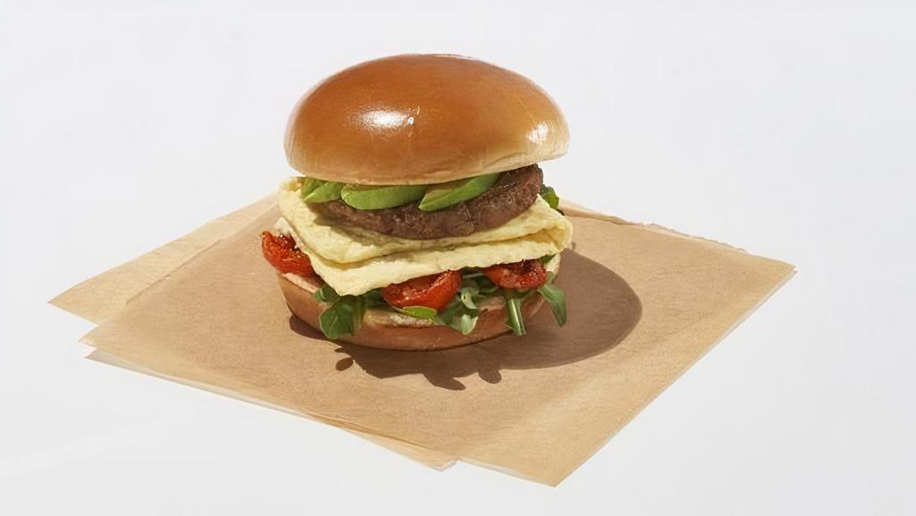 The Plant-Based Cali · Avocado, roasted tomatoes, baby arugula, plant-based sausage patty, folded plant-based egg on a vegan bun.