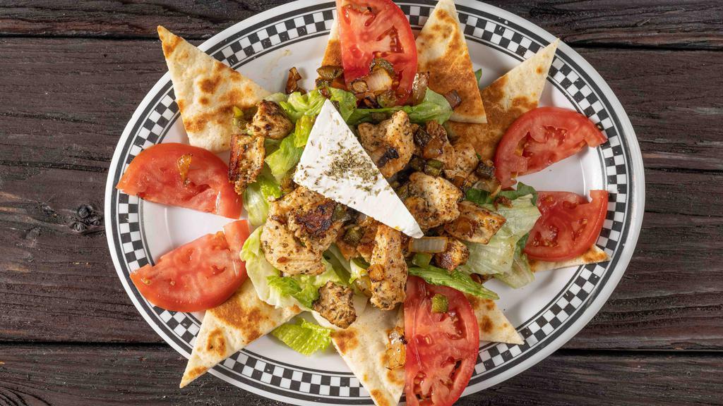 Chicken Souvlaki · Marinated in garlic, oil and herbs, grilled with onions and peppers, served open faced with tomato and lettuce, on a pita bread and our own tzatziki sauce.