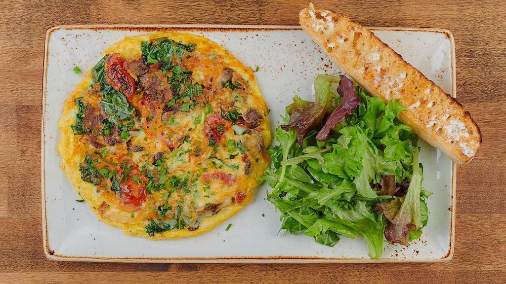 Frittata Rustica · A classic Italian-style omelet with kale, house-roasted Crimini mushrooms, onions and tomatoes topped with Mozzarella and Parmesan cheese. Served with ciabatta toast and lemon-dressed organic mixed greens.